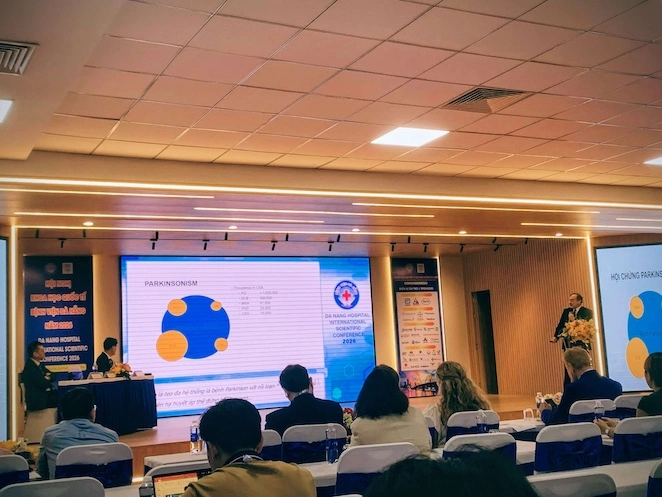 Diễn giả đang trình bày trên sân khấu lớn với màn hình LED phía sau